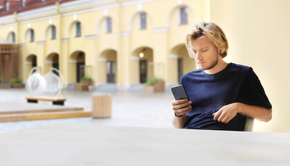 Lifestyle portrait of a young man using a smart phone outdoors