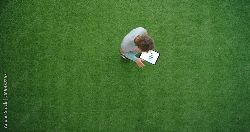 Aufkleber Business man using a digital tablet on a hoverboard in a trendy creative startup from above. Overhead of a young designer or student analyzing graphs on a wireless device while riding in circles