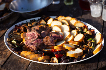 a large plate of meat on a picnic table