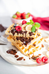 delicious belgian breakfast waffles with strawberries and raspberries and chocolate and banana