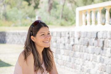 Young woman enjoying the day in a park, in a sporty outfit doing activities and exercises.