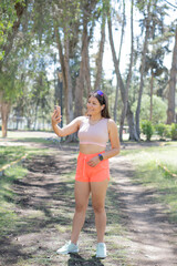 Young sporty woman enjoying a nice day enjoying music on her cell phone.