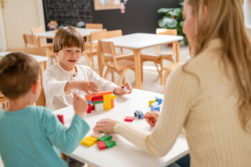 Kindergarten children playing with colorful building blocks. Healthy learning environment. Learning through play.