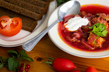 Beetroot soup called borsch with meat, potatos and cabbage and traditional russian black bread or rye bread