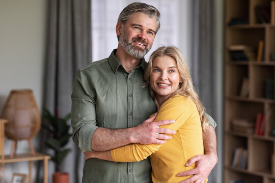 Portrait Of Happy Married Middle Aged Couple Hugging At Home