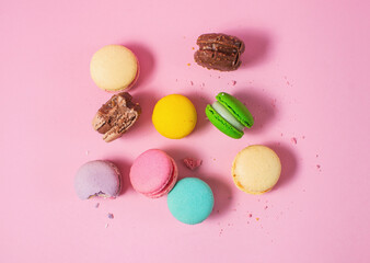 Bright colorful various flavor macarons sweet cookies on pink background.