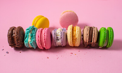 Bright colorful various flavor macarons sweet cookies on pink background