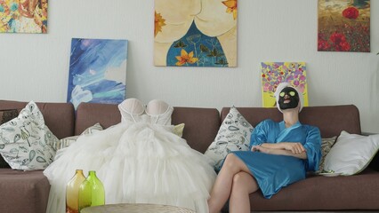 4K. The bride is preparing for the wedding, she makes a fabric mask on her face
