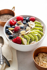 Smoothie bowl with fresh berries, kiwi, oats, chia seeds. Breakfast healthy meal, bright background