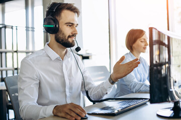 Man and woman working in call center office and consulting people