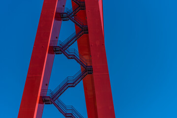 Stairs up the side of a giant red gantry crane.