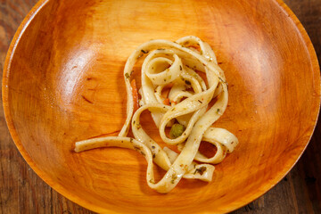 Boiled udon lies in a wooden plate.