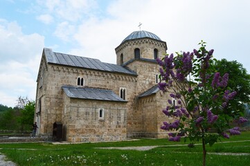 Fototapeta na wymiar old stone orthodox monastery and lilac