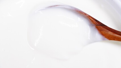 Close up of wooden spoon dipping in yogurt