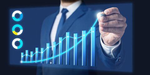 Businessman draws growth graph of business in virtual screen. Business development and planning concept