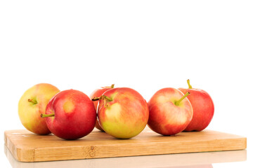 Several red sweet apples on a kitchen board, close-up, on a white background.