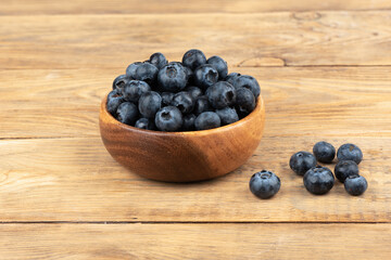 Blueberries on a wooden background with space for text.