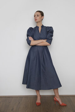Serie of studio photos of young female model wearing puff sleeved cotton denim dress