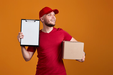 Delivery man holding clipboard and empty cardboard box i