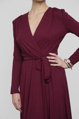 Serie of studio photos of young female model in burgundy wrap dress. 