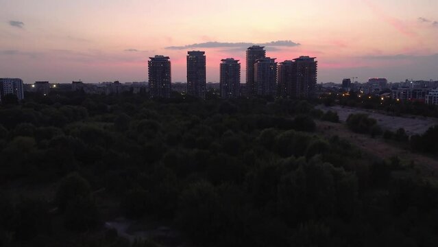 After sunset aerial view of Bucharest city skyline from Vacaresti Delta with high buildings in the middle and People's House and lots of the city landmarks in background