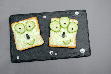 Funny monster faces on halloween sandwich toast bread with soft green avocado cheese ricotta...
