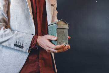 man holding small vintage metal piggy bank