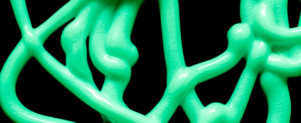 green tangle of stream of liquid silicone on a black background