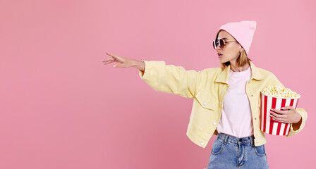 woman watching movie film, holding bucket of popcorn