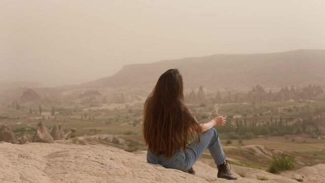 Man approaching and hugging faceless girlfriend on cliff 