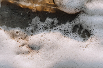 Background, texture from the beach of white foam from the sea, ocean on the sand. Photography of nature.