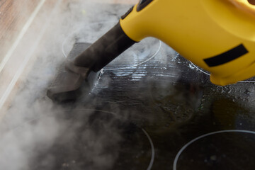 Cleaning of induction cooker with steam cleaner.