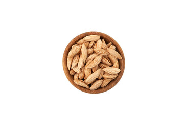 Dried Uzbek almonds or Bukhara wild almonds in wooden bowl on white background, top view