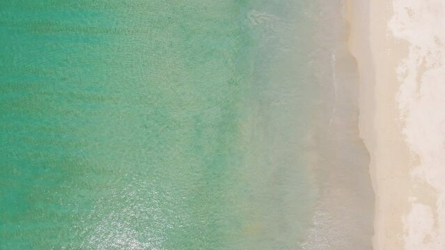 Professional video 4K High angle view Top-down camera over beach sand with seawater Beautiful seawater clear on sandy beach in sunset time.
