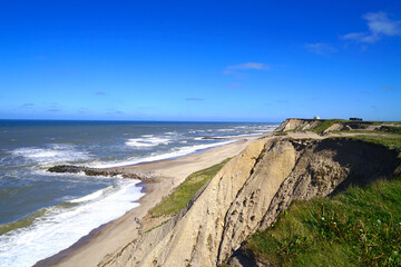 cliff of the North Sea coast near the bovbjerg fyr lighthouse and the beach and groyne, denmark,...