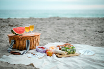 Picnic is set up on the beach. Wicker basket with food and drink for romantic picnic and relaxing....