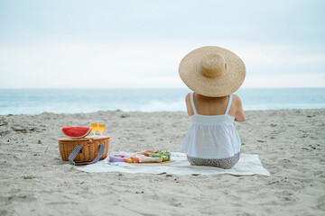 woman is sitting and looking at the beach. Vacation and picnic concept for summer.