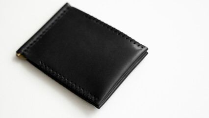 Brown men's money clip handmade leather wallet. Empty money clip wallet with a two pockets for cards lies on a white table. Selective focus, copy space.