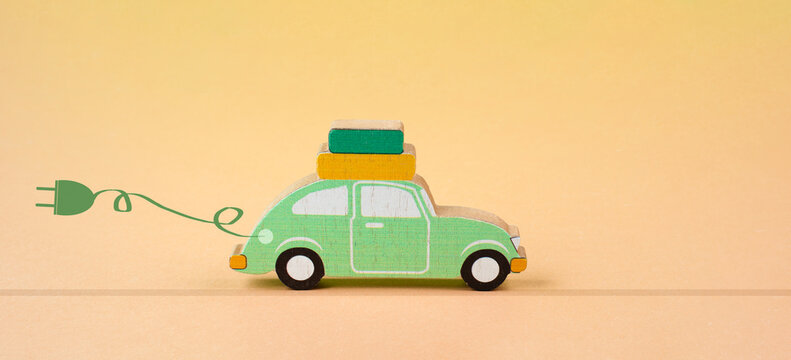 Small Green Electric Car With A Cable For Recharging, Vacation Trip With Eco Power