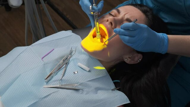 Female dentist with cartridge syringe injecting anesthetic medicine before teeth treatment