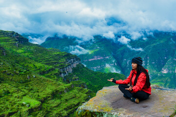 Naklejka premium woman on top of the mountain concentrated, breathing fresh air