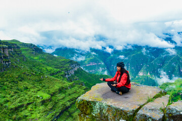 Fototapeta premium woman on top of the mountain concentrated, breathing fresh air