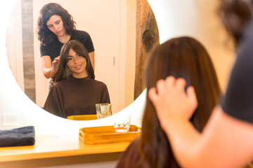 Hairdresser combing and finishing treatment in the beauty salon with a dryer, hairdressing
