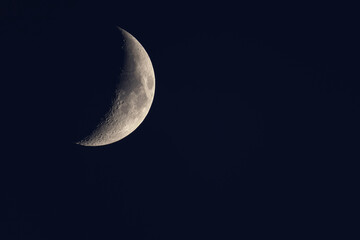 Obraz na płótnie Canvas Waxing crescent moon in the summer night sky.