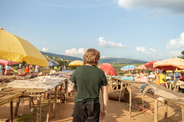 Back view of nale tourist visiting the Kimironko market in Rwanda capital city.