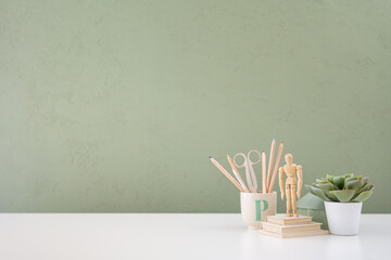 Home office desk with old books, school supplies and empty table space.	