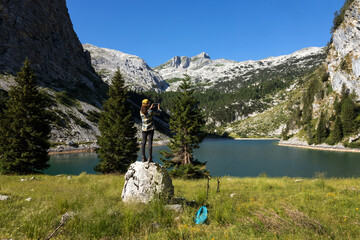 Woman Trekker taking a Photograph of Environment Around Lake of Krn in Julian Alps Slovenia