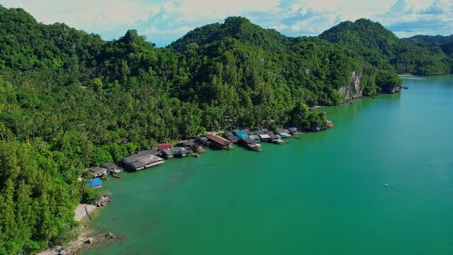 Fishing village at Ban Ao Kram. Ban Ao Kram has a homestay for tourists to stay and learn about the lifestyle of fishermen. Tropical sea at Chumphon, Thailand. Cinematic drone shot. 4k
