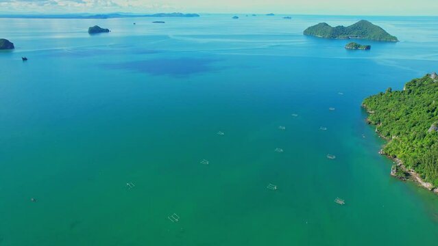 Drones are flying over the beautiful sea, many islands in the background, fish traps and squid traps on the sea, the fishing industry in Ao Kram, Chumphon, Southern Thailand. 4K drone footage
