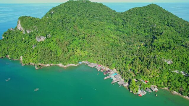 Fishing village at Ban Ao Kram. Ban Ao Kram has a homestay for tourists to stay and learn about the lifestyle of fishermen. Tropical sea at Chumphon, Thailand. Cinematic drone shot. 4k
